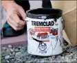  ??  ?? Police seize one of two cans of black Tremclad paint that were found nearby.