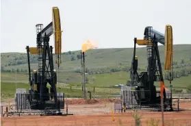  ?? Charles Rex Arbogast / Associated Press ?? Oil wells, like these in North Dakota, could pump less if prices make them not worth operating. Oil is now selling for less than $85 per barrel, but would have to fall under $80 per barrel for an extended period of time to curtail production, analysts...