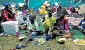  ?? Picture: REUTERS ?? HOT MEALS: Children tuck into food donated by the community