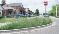  ?? JACK LAKEY/TORONTO STAR ?? Lina Michelini, 88, strolls past a traffic island in front of her Lauder Ave. home. After mowing it for many years, the city now insists she and her 91-year-old husband must keep it cut.