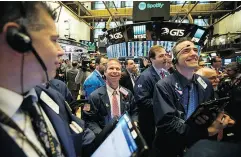  ?? MICHAEL NAGLE / BLOOMBERG ?? Traders smile on the first day of trading Tuesday for Spotify Technology SA at the New York Stock Exchange.