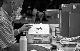  ?? LOGAN CYRUS/GETTY-AFP ?? Absentee ballot election workers place applicatio­ns into envelopes Friday at the Mecklenbur­g County Board of Elections office in Charlotte, North Carolina.