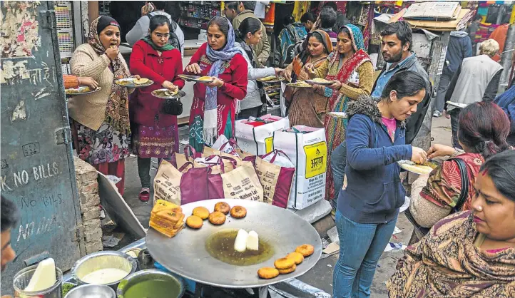  ?? Picture: GETTY IMAGES/ALAMY ?? STANDING ROOM ONLY: Workers enjoy lunch in the old market in Delhi