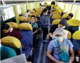  ?? AP ?? Overseas Filipino workers, who were quarantine­d as they arrived in the country weeks ago, wait inside a bus before they head back to their provinces on Tuesday.