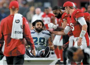  ?? AP PHOTO ?? Seattle Seahawks defensive back Earl Thomas is greeted by Arizona Cardinals players as he leaves the field after breaking his leg during the second half of Sunday’s game in Glendale, Ariz. The Seahawks won 20-17.