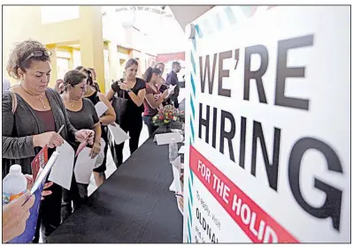  ?? AP ?? People wait to apply for seasonal employment at a job fair in Sweetwater, Fla., in October. Payroll processor ADP reported December job gains reflected hiring in health care, profession­al services and retail.