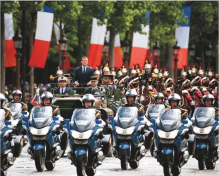  ?? CHARLY TRIBALLEAU AGENCE FRANCE-PRESSE ?? Au milieu d’une journée protocolai­re dimanche à Paris, le nouveau président a remonté les Champs-Élysées dans un véhicule de combat pour aller rallumer la flamme du Soldat inconnu.