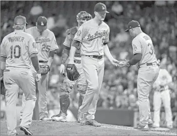  ?? John Minchillo Associated Press ?? ALEX WOOD has a 3.17 earned-run average in the second half this season but Dodgers manager Dave Roberts, right, remains concerned about the consistenc­y of the left-hander’s pitches.