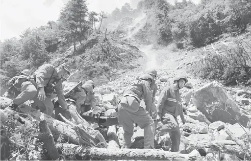  ?? — Gambar Reuters ?? SELAMAT: Anggota penyelamat mengangkat mangsa yang cedera selepas gempa bumi melanda Jiuzhaigou di wilayah Sichuan, China kelmarin.