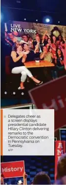  ?? AFP ?? Delegates cheer as a screen displays presidenti­al candidate Hillary Clinton delivering remarks to the Democratic convention in Pennsylvan­ia on Tuesday.