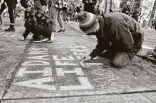  ?? Andy Atkinson / Medford Mail Tribune ?? Toren McKnight of Central Point colors a message in chalk art Wednesday at a vigil for Aidan Ellison at the Jackson County Justice building in downtown Medford, Ore.