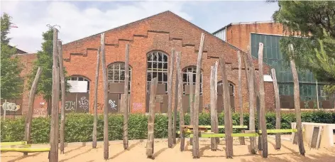  ?? FOTOS (3): L. HAUSER ?? Vom Spielplatz in der Bahnstadt aus gesehen: ein Teil der alten Ausbesseru­ngshallen. Wo es geht, sollen Fassadenbe­reiche erhalten bleiben.