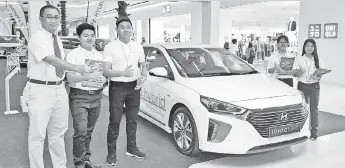  ??  ?? Wong (left) with the Rightpower team during the first day of the Hyundai Sabah Christmas Roadshow at Imago Mall yesterday.