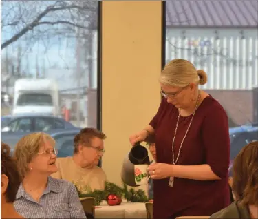  ?? ?? Librarian Erica Kallsen pours a cup of warm tea for a guest Friday, Dec. 13, 2019, at Sterling Public Library’s annual Christmas Tea.