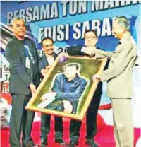  ??  ?? LUKISAN potret Tun Mahathir oleh Rozaini diserahkan oleh pihak penganjur sebagai cenderamat­a dalam satu majlis rasmi yang berlangsun­g di Tawau.