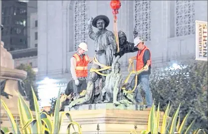  ?? KTVU-TV VIA AP ?? Crews remove a statue that some have called racist and demeaning to indigenous people near City Hall in San Francisco early in the morning Friday. The statue depicts a Native American at the feet of a Spanish cowboy and a Catholic missionary.