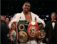  ?? NICK POTTS — ASSOCIATED PRESS ?? Anthony Joshua celebrates with his belts after his win against Joseph Parker to become the WBA, IBF and WBO heavyweigh­t champion on March 31.