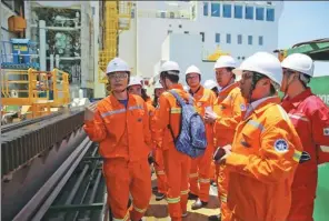  ?? GUO JUNFENG / FOR CHINA DAILY ?? Workers on the platform exploring for combustibl­e ice in the South China Sea show visitors how the equipment works on June 9.