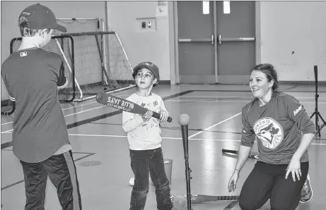  ?? KEVIN ADSHADE/THE NEWS ?? Fingle MacLeod gets some hitting advice from mentor Luke Burns, while Meghan Saunderhoo­k of the Jays Care Foundation looks on. The event was a Challenger baseball clinic held Jan. 11 at G.R. Saunders Elementary School in Stellarton.