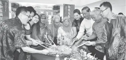  ??  ?? MOGA MAKMUR: Tun Salahuddin, Norkiah (tengah) serta Rodziah, Soo, Troy, William (kiri) dan Mataip, Hii dan Pau (kanan) menggaul ‘Yee Sang’ pada Majlis Rumah Terbuka Tahun Baharu Cina BDA, semalam.