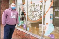  ?? Grace Duffield / Hearst Connecticu­t Media ?? Daniel Vieira outside LivFree, an organizati­on that helps families affected by pediatric cancer, at 107 Main St. in New Canaan. Below, he stands before pictures of many of the 300-plus families the nonprofit has sponsored for a fun outing.