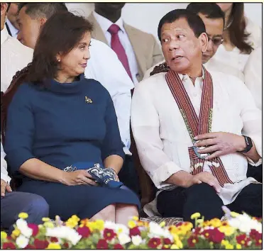  ?? KRIZJOHN ROSALES ?? President Duterte chats with Vice President Leni Robredo during the commenceme­nt exercises of the Philippine National Police Academy’s Masidlak Class in Silang, Cavite yesterday. He earlier said if she was in a hurry to be president, she should just...