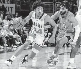  ?? AL DIAZ adiaz@miamiheral­d.com ?? Nijel Pack, driving to the basket Saturday against North Carolina’s RJ Davis, felt knee pain in the second half. Pack and Kyshawn George (ankle) are not certain to play against Clemson.