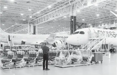  ?? RYAN REMIORZ, THE CANADIAN PRESS ?? Bombardier employees work on CSeries 300 jets for SwissAir and Korea Airlines at the company’s plant Thursday in Mirabel, Que.