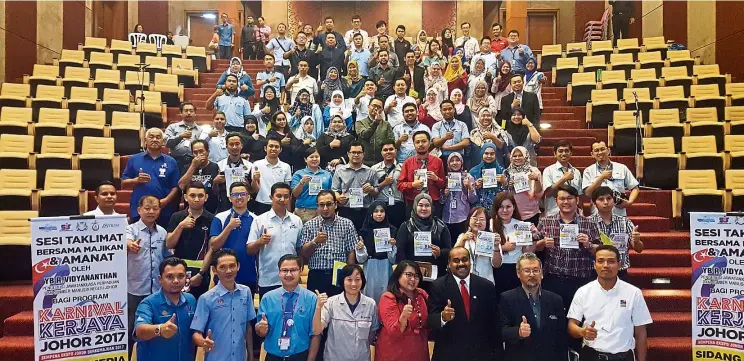  ??  ?? Vidyananth­an (front row, third from right) along with employers giving the thumbs up during a briefing for the Johor Career Carnival in Kota Iskandar on Oct 4, 2017.