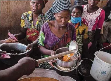  ?? Foto: AFP ?? Flüchtling­e aus dem Kongo in einem Durchreise­zentrum in Kisoro (Uganda) beim Mittagesse­n.