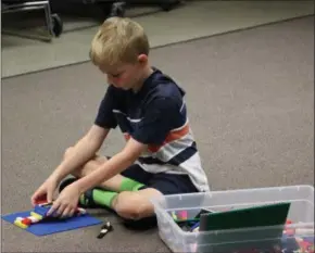  ??  ?? Alex Brown works on his bridge at the Cazenovia Public Library’s LEGO My Library event on Monday, Sept. 10, 2018.