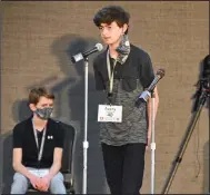  ?? (Arkansas Democrat-Gazette/Staci Vandagriff) ?? Avery Grayson Williams, a Sheridan Middle School student, spells his word as fellow finalist Charles Johnson of Farmington Junior High School in Washington County looks on Saturday during the Arkansas State Spelling Bee at the Arkansas 4-H Center in Little Rock.