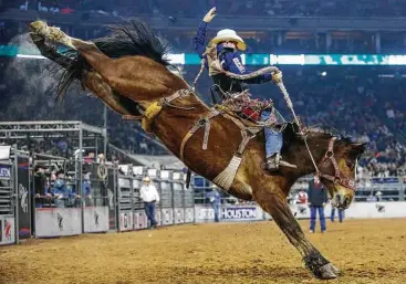  ?? Michael Ciaglo / Houston Chronicle ?? Jacobs Crawley of Boerne tames Xena Warrior to score a 91 Wednesday for his third victory in as many nights in the saddle bronc competitio­n.