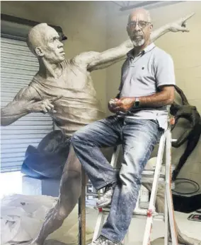  ??  ?? Sculptor Basil Watson as he worked on the statue dedicated to sprinter Usain Bolt, which now stands at Independen­ce Park outside the National Stadium in St Andrew.