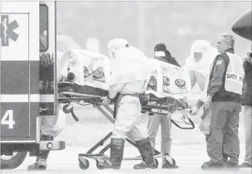  ?? NATI HARNIK /ASSOCIATED PRESS ?? Health workers in protective suits transport Dr. Martin Salia, a surgeon working in Sierra Leone who had been diagnosed with Ebola, from a jet to a waiting ambulance that took him to the Nebraska Medical Center in Omaha. Ebola treatment in the US by the numbers:Nine people with Ebola have received medical treatment in the United States, many of them aid workers.Five of the nine people treated in the United States were — like Salia — diagnosed with Ebola in West Africa and flown to the United States.Four U.S. hospitals have specialize­d treatment units for people with highly infectious diseases, including the largest one at the Nebraska Medical Center in Omaha. The others are at Emory University Hospital in Atlanta, the National Institutes of Health near Washington and St. Patrick Hospital in Missoula, Montana.Two cases of Ebola have originated in the United States. Two Dallas nurses — Nina Pham and Amber Vinson — were infected while caring for a Liberian man sick with the disease. Both of the nurses have recovered.There has been only one Ebola death in the United States. Thomas Eric Duncan became sick days after arriving in Dallas from Liberia. He went to the emergency room at Texas Health Presbyteri­an Hospital but was sent home, which the hospital has acknowledg­ed was a mistake. He returned a few days later, was diagnosed with Ebola and died Oct. 8.