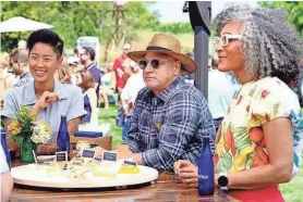  ?? ?? “Top Chef: Wisconsin” host Kristen Kish, from left, judge Tom Colicchio and guest judge Carla Hall discuss contestant dishes around a plate of Wisconsin cheese during Episode 3, “Take it Cheesy,” which was filmed at The Cupola Barn in Oconomowoc.