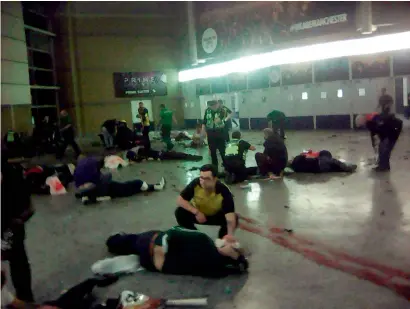  ?? AP ?? Helpers attend to injured people inside the Manchester Arena, Manchester, after the suicide blast on Monday. —