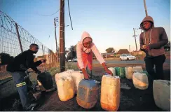  ??  ?? Men and women collect water in the early hours of the morning in Koster after water was cut — in retaliatio­n for service delivery protests, say some.
