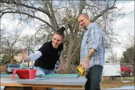  ?? CONTRIBUTE­D BY HGTV ?? Jen and Brandon Hatmaker finish painting the cabinets for their new kitchen, as seen on HGTV’s “My Big Family Renovation.”