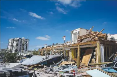  ?? AP PHOTO/REBECCA BLACKWELL ?? Robert Leisure surveys the wreckage of his business, Getaway Marina, which was destroyed during the passage of Hurricane Ian, Thursday in Fort Myers Beach, Fla.