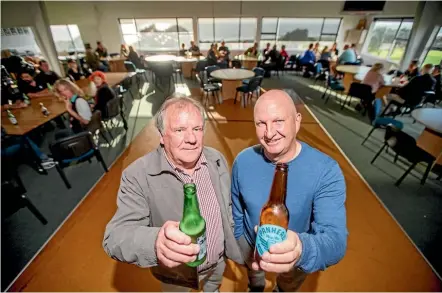  ?? ANDY JACKSON/STUFF ?? Fitzroy Golf Club president Mike Earley and Taranaki Golf executive officer Nick Northam crack a beer to officially celebrate their, and the community’s, success.