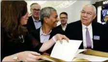  ?? RICHARD DREW — THE ASSOCIATED PRESS ?? Bloom Energy Founder, President and CEO K.R. Sridhar, center accompanie­d by board member Colin Powell, right, prepares to sign the New York Stock Exchange guest book with NYSE President Stacey Cunningham before their IPO, Wednesday.