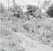  ??  ?? TINDAKAN SEGERA: Kerja-kerja membuat saliran parit dari danau yang mendatangk­an masalah banjir jalan raya di Kg. Giling telah mula dilakukan.