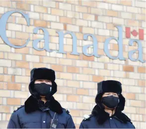  ?? GREG BAKER / AFP / GETTY IMAGES ?? Chinese police officers stand guard outside the Canadian embassy in Beijing on Monday.