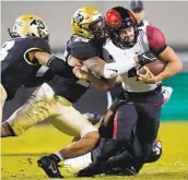  ?? DAVID ZALUBOWSKI AP ?? Aztecs quarterbac­k Jordon Brookshire is dragged down after a short gain. He rushed for 50 yards.