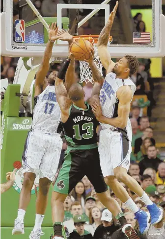  ?? HERALD PHOTO BY MARY SCHWALM ?? BLOCKED OUT: The Celtics’ Marcus Morris has nowhere to go in yesterday’s game at the Garden thanks to Orlando’s Jonathon Simmons and Khem Birch.