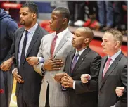  ?? DAVID JABLONSKI / STAFF ?? Dayton coaches, including Anthony Grant (second from left) stand for the national anthem before a game against North Florida on Wednesday.