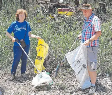  ??  ?? CLEAN-UP: Volunteers Odette Aspinall and Andrew Smart at Chinaman Creek. Picture: JUSTIN BRIERTY