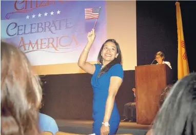  ?? MARLA BROSE/JOURNAL ?? An excited Bijena Adhikari, who was born in Nepal, waves an American flag after taking the Oath of Allegiance on Wednesday and becoming a U.S. citizen.