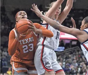  ?? JESSICA HILL/AP ?? Texas’ Aaliyah Moore (23) shoots as Connecticu­t’s Dorka Juhasz (14) defends during the second half on Nov. 14 in Storrs, Conn.